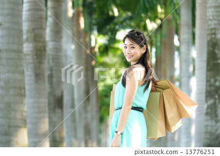 One young chinese woman shopaholic along promenade 13776251