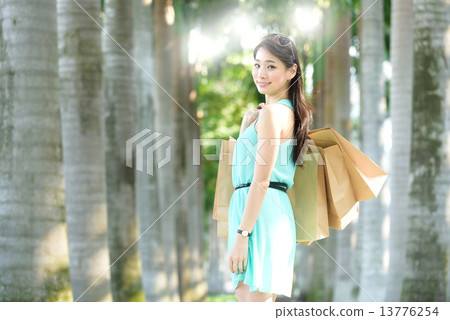 One young chinese woman shopaholic along promenade 13776254