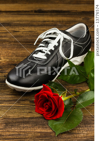 black man's shoe and rose 13776574