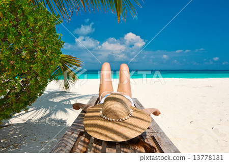 Woman at beach lying on chaise lounge Woman at beach lying on chaise lounge 13778181