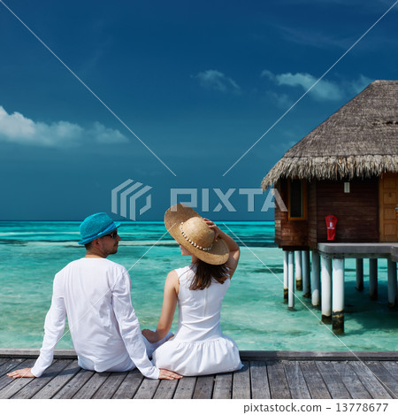 Couple on a beach jetty at Maldives 13778677