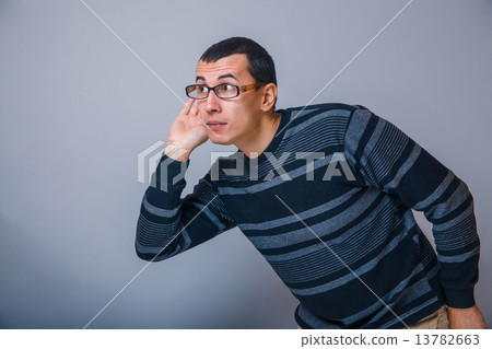 male of European appearance brunet put his hand to ear eaves 13782663