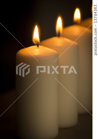 Candles lights burning close-up plain background 13784363
