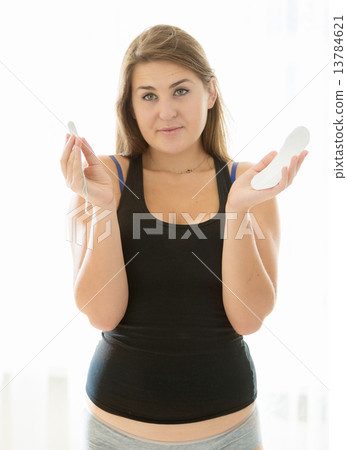 brunette woman holding menstrual pad and tampon brunette woman holding menstrual pad and tampon 13784621