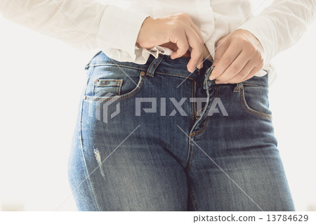 sexy woman unbuttoning her jeans 13784629