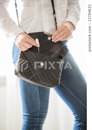 young stylish woman taking tampon from handbag young stylish woman taking tampon from handbag 13784632