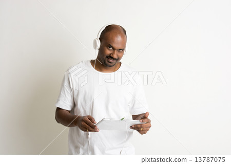 casual indian male on jeans and shirt and a tablet casual indian male on jeans and shirt and a tablet 13787075