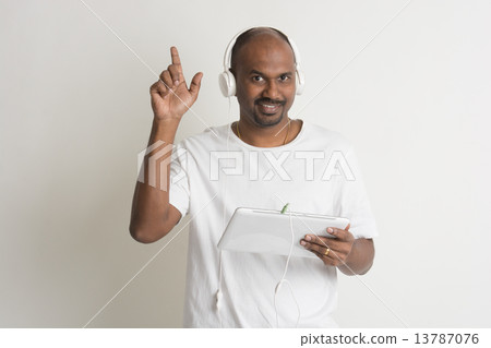 casual indian male on jeans and shirt and a tablet casual indian male on jeans and shirt and a tablet 13787076