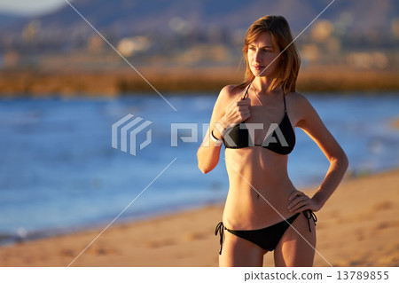 Young woman in bikini posing on sea coast Young woman in bikini posing on sea coast 13789855
