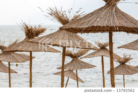 Straw umbrellas on sea background 13793562