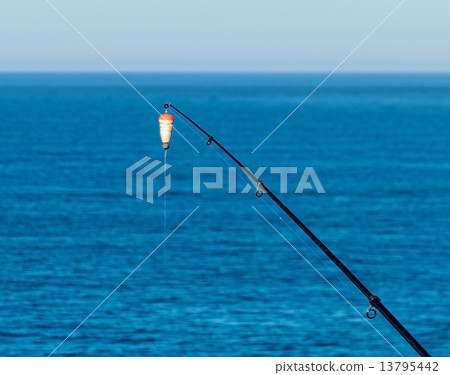 Fishing Bait-Rod with Float against the Blue Sea Water Surface 13795442