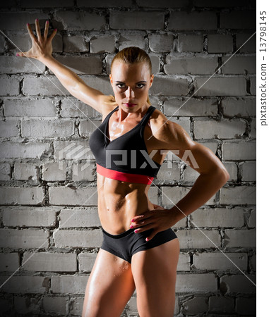 Muscular woman on brick wall (normal version) Muscular woman on brick wall (normal version) 13798145