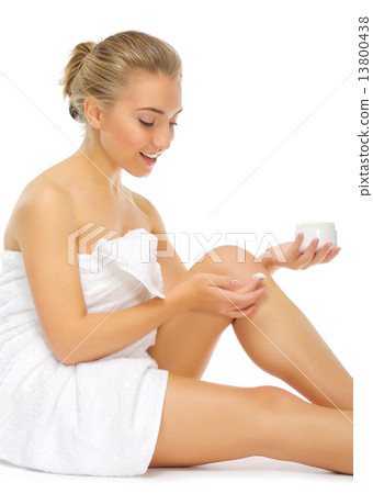 Young girl applying body cream 13800438