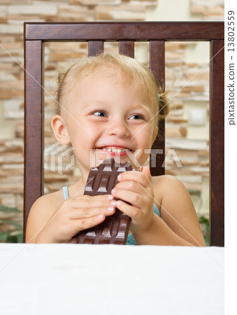 Little girl with chocolate at light room 13802559
