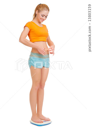 Smiling young woman on scales 13803159