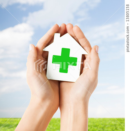 hands holding paper house with green cross hands holding paper house with green cross 13805158