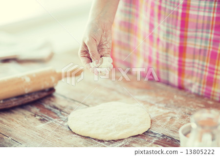 closeup of female hand sprinkling dough with flour closeup of female hand sprinkling dough with flour 13805222