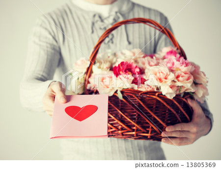 man holding basket full of flowers and postcard 13805369