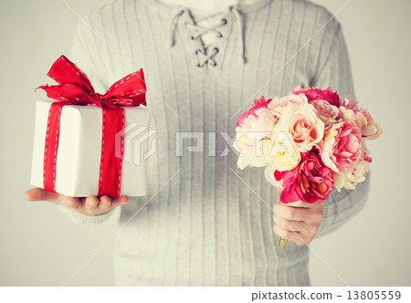 man holding bouquet of flowers and gift box man holding bouquet of flowers and gift box 13805559
