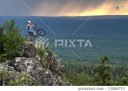 Biker with mountain bicycle stands on peak 13806751