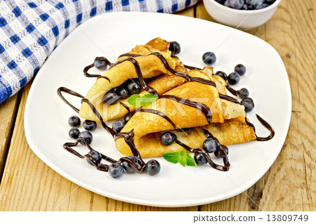 Pancakes with blueberries and chocolate on board 13809749