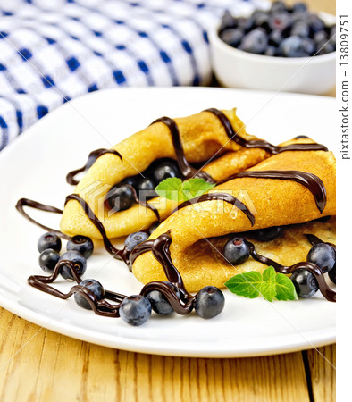 Pancakes with blueberries and chocolate on wooden board 13809751