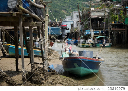 Blue boat moored beside Chinese stilted house 13810979