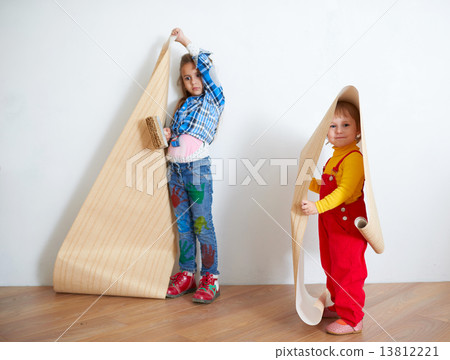 girls hanging wallpaper. Decorating the wall girls hanging wallpaper. Decorating the wall 13812221