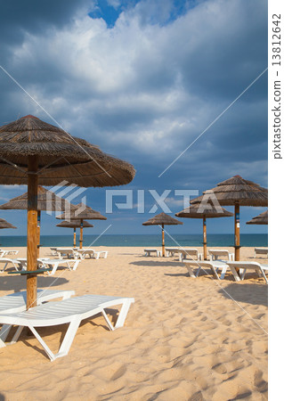 Different parasols and sun loungers on the empty beach on Tavira 13812642