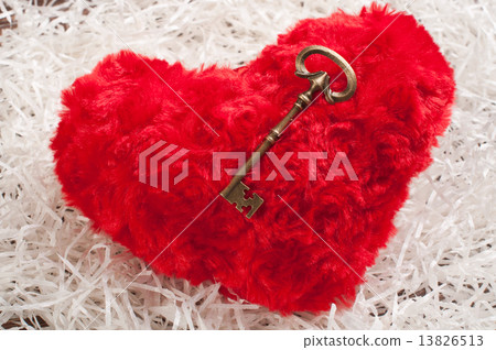 red toy heart on white paper wih the key 13826513