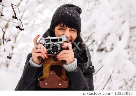 smiling girl photographed on a camera in winter forest smiling girl photographed on a camera in winter forest 13833053
