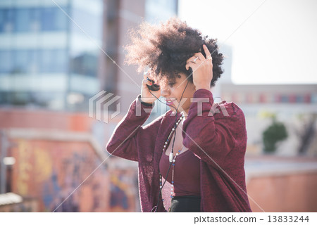 beautiful black curly hair african woman listening music with he 13833244