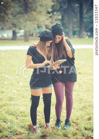 young couple beautiful women girls autumn using tablet young couple beautiful women girls autumn using tablet 13833347