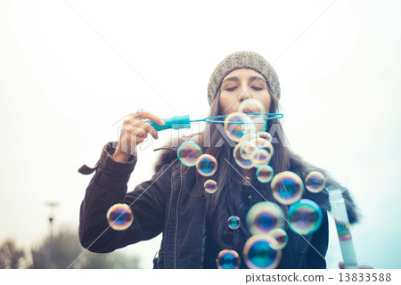 young beautiful brunette woman blowing bubble soap 13833588