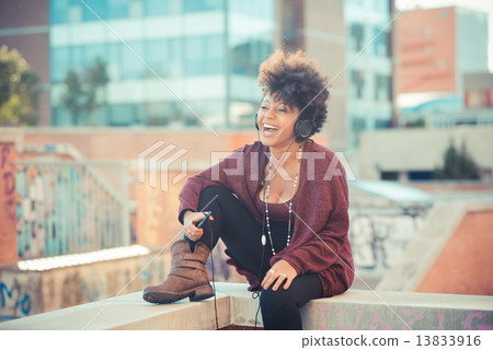 beautiful black curly hair african woman listening music with he 13833916