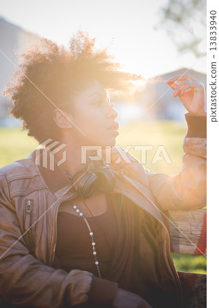 beautiful black curly hair african woman listening music with he 13833940