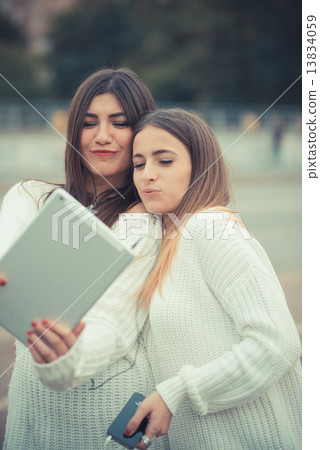 young couple beautiful women girls autumn using tablet young couple beautiful women girls autumn using tablet 13834059