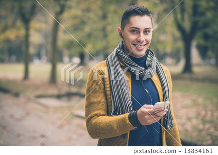 young handsome caucasian man in autumn park 13834161