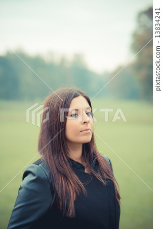 young beautiful brunette straight hair woman in the park 13834241