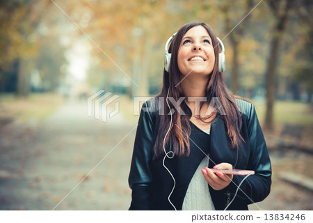 young beautiful brunette straight hair woman in the park 13834246