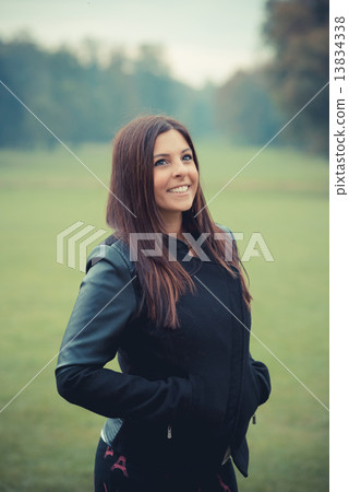 young beautiful brunette straight hair woman in the park 13834338