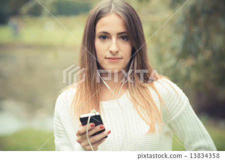 young beautiful woman girl autumn listening music 13834358