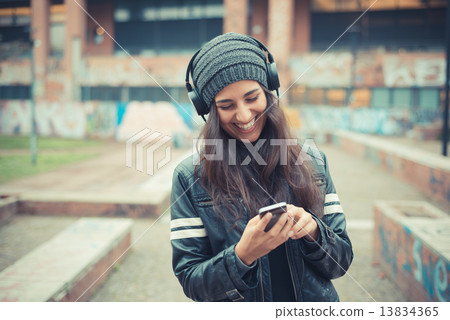 young beautiful brunette woman listening music with headphones 13834365