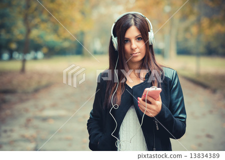 young beautiful brunette straight hair woman in the park 13834389