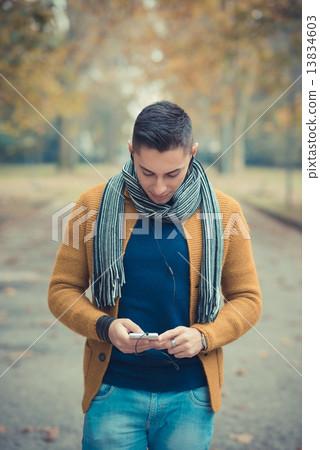 young handsome caucasian man in autumn park 13834603