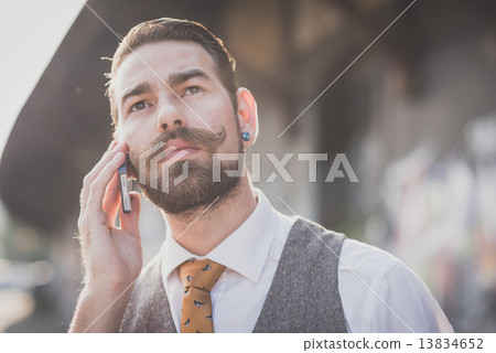 handsome big moustache hipster man calling with cellphone 13834652