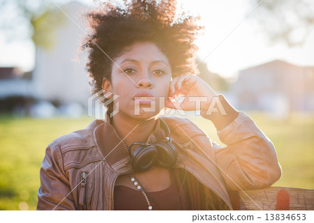 beautiful black curly hair african woman listening music with he 13834653