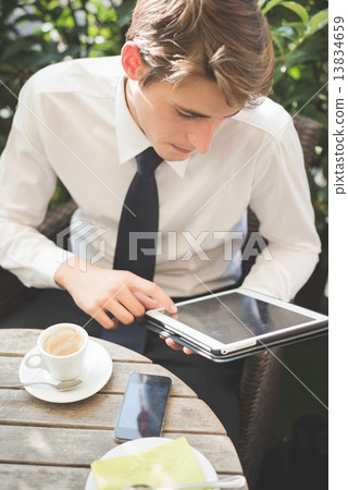young handsome elegant blonde model businessman working with tab young handsome elegant blonde model businessman working with tab 13834659