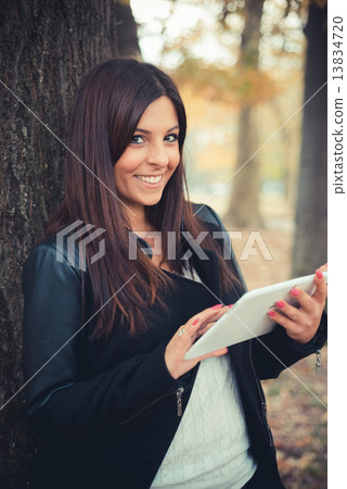 young beautiful brunette straight hair woman in the park 13834720