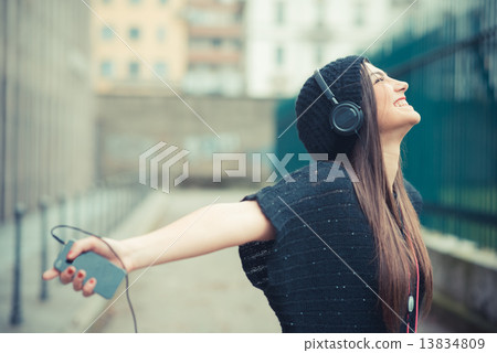 young beautiful brunette woman girl listening music headphones 13834809